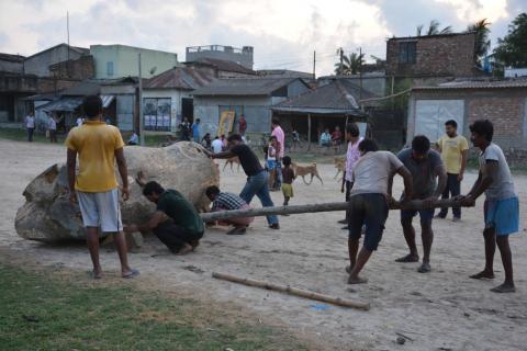 People pushing a log in Gosaba market