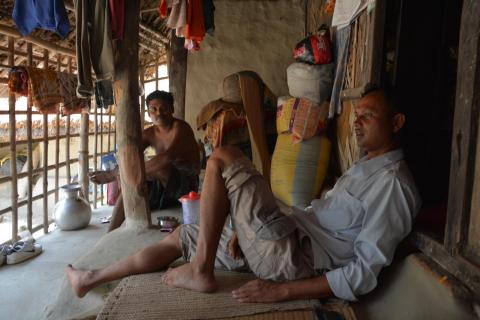 Villagers relaxing inside a mud hut